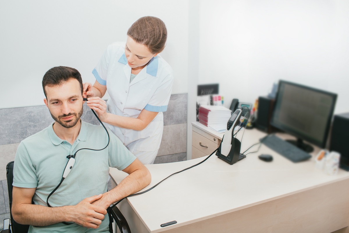 Audiologist giving patient a hearing test