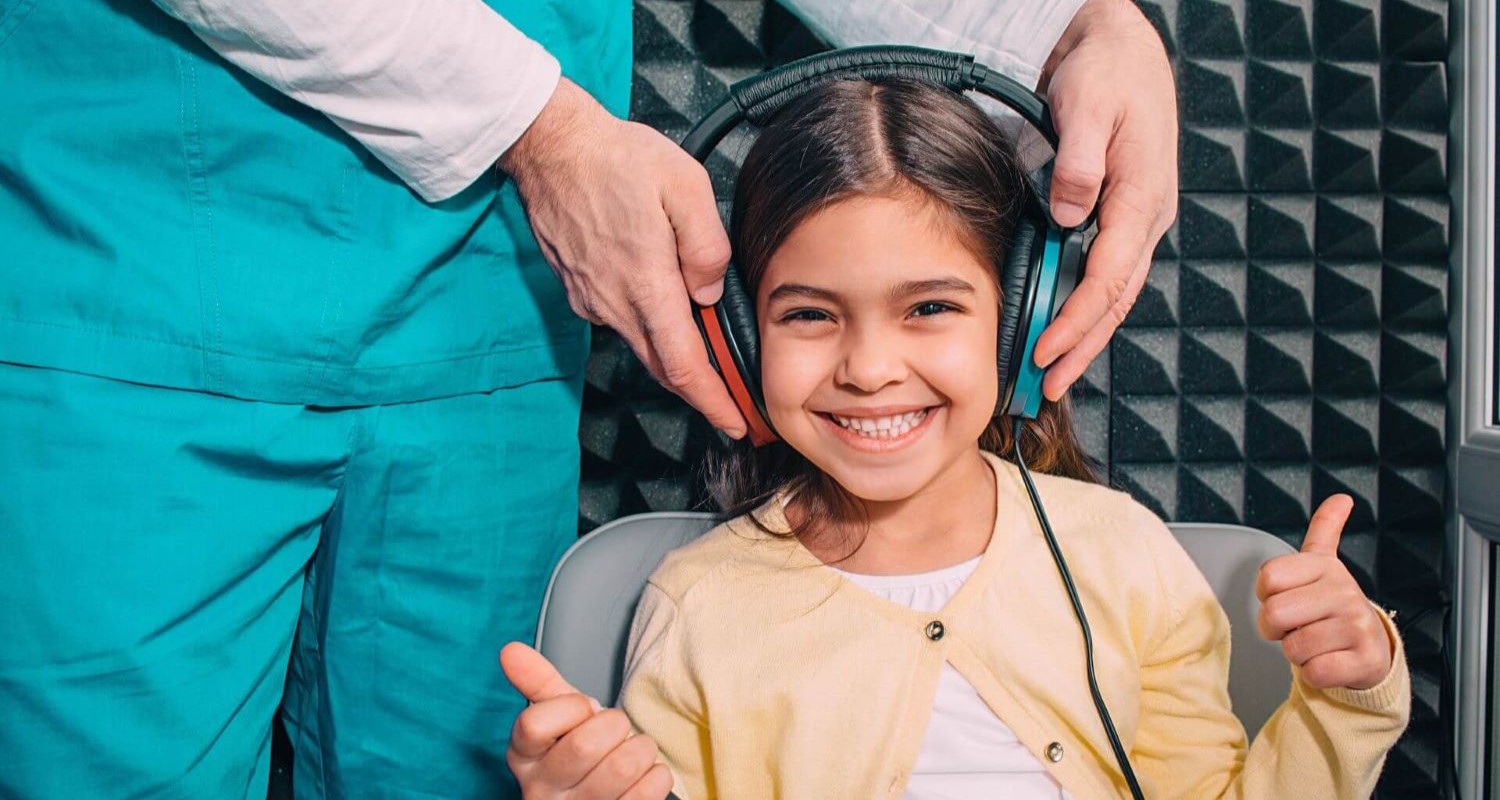 Child in hearing booth getting hearing test