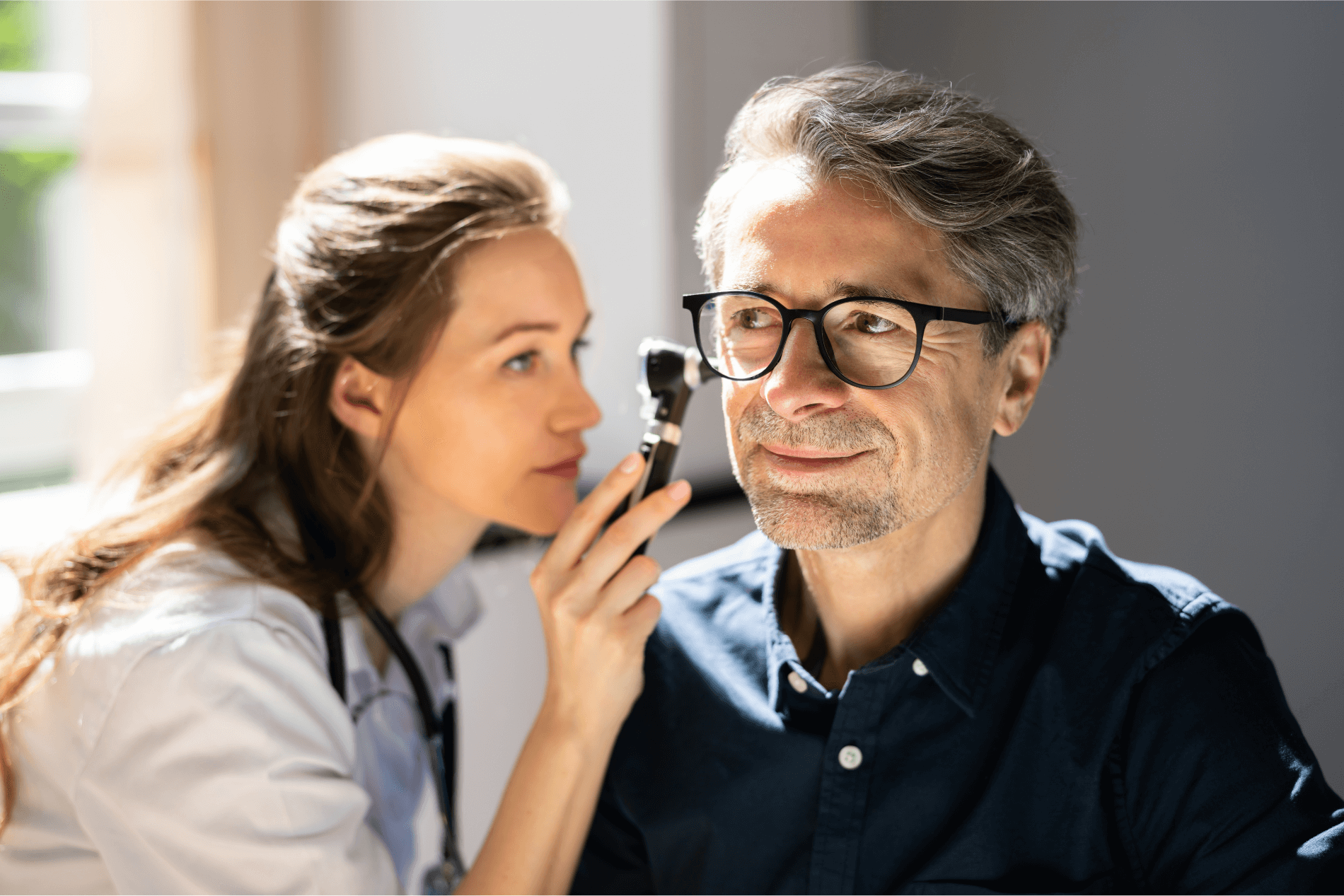 Audiologist giving patient ear exam